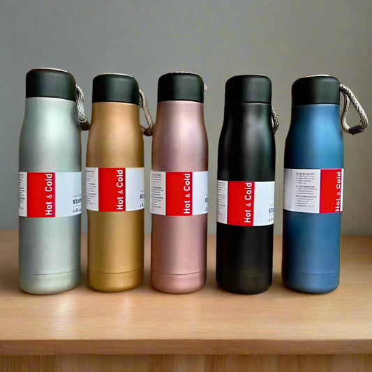 Set of five insulated bottles with colorful labels on a wooden surface.