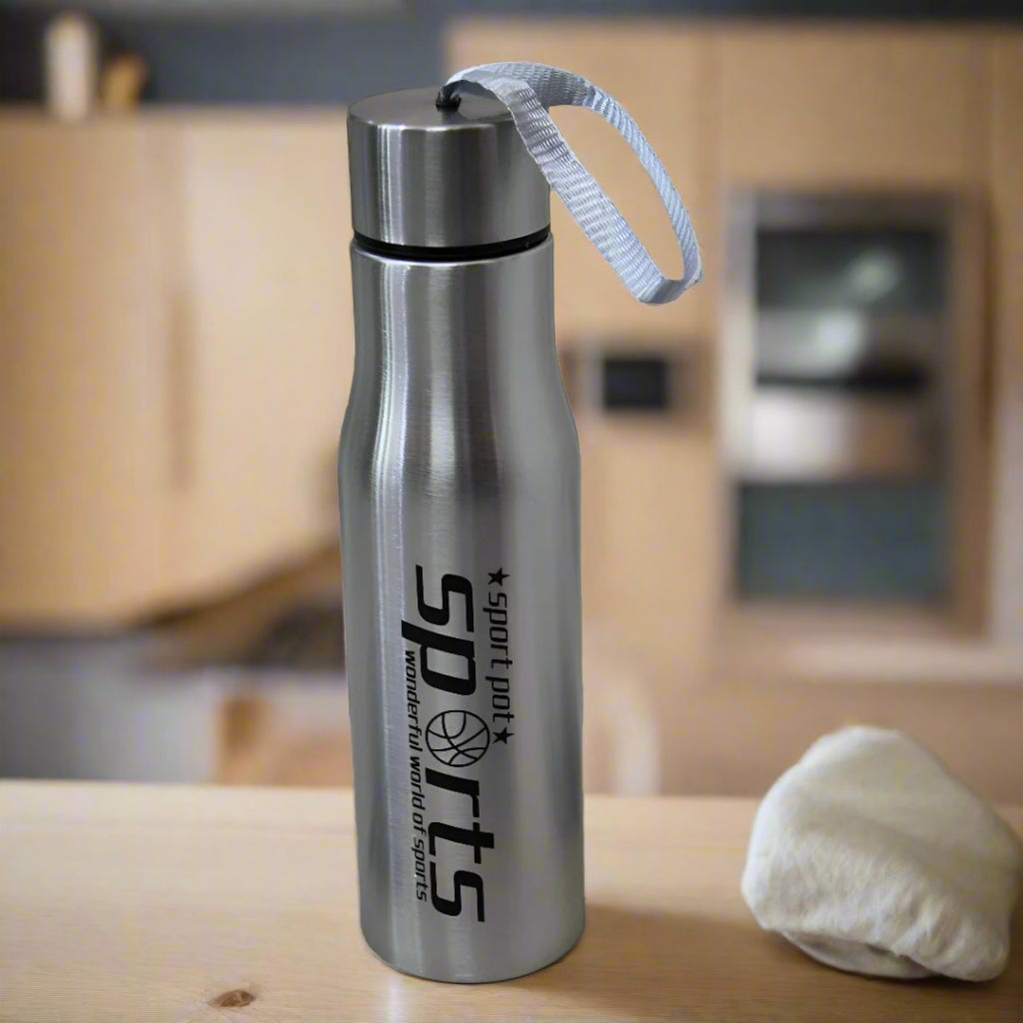 Silver water bottle with 'Sport Dad' branding on a wooden surface